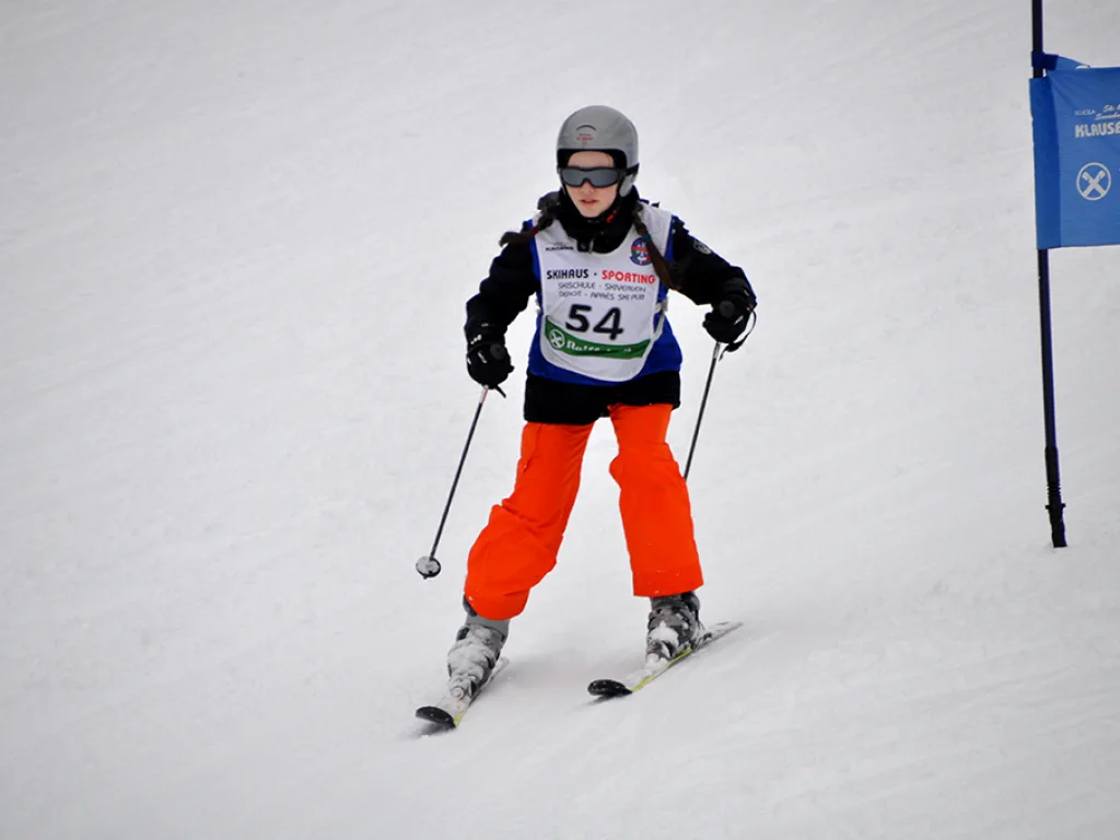 Skifahrer mit Startnummer 54 in oranger Hose.